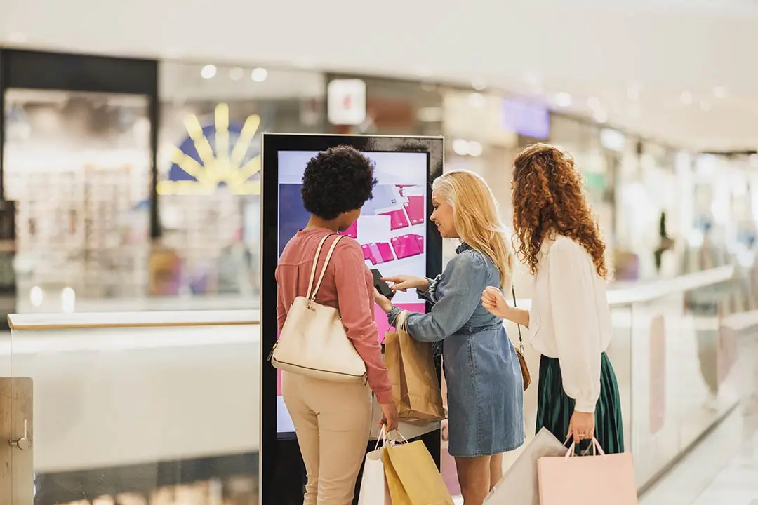 T&oacute;tem publicitario de dise&ntilde;o elegante situado en la entrada de un local comercial para captar la atenci&oacute;n de los peatones.