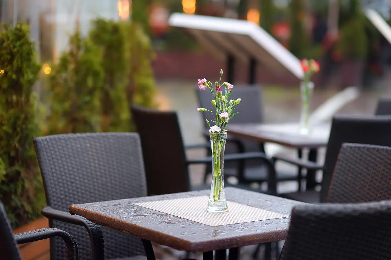 Terraza de bar moderna y equipada con estufas y pizarras publicitarias.